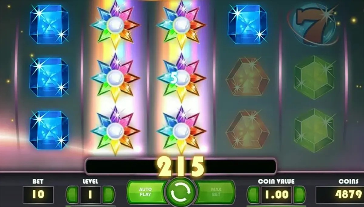 Starburst slot screenshot showing reels with blue gems and stacked rainbow Starburst wild symbols on two middle reels, with a win of 215 displayed above the green spin button and betting controls along the bottom.