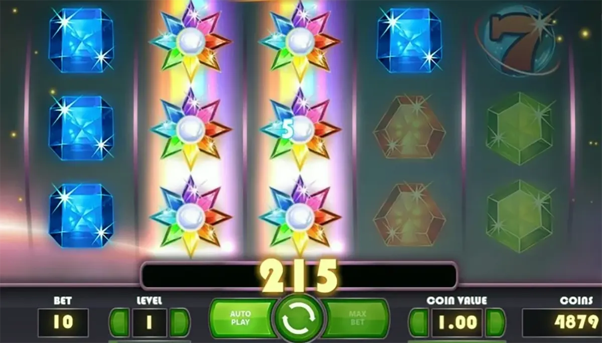 Starburst slot screenshot showing reels with blue gems and stacked rainbow Starburst wild symbols on two middle reels, with a win of 215 displayed above the green spin button and betting controls along the bottom.
